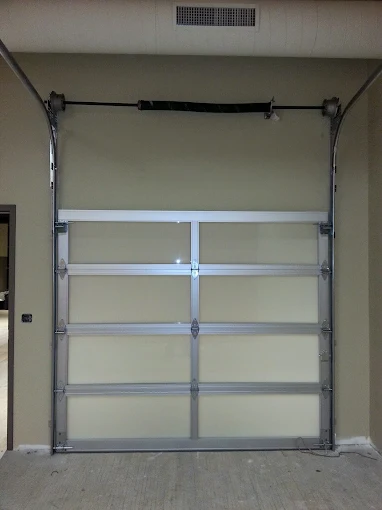 A closed aluminum garage door installed on an indoor wall with no visible opening to the outside.